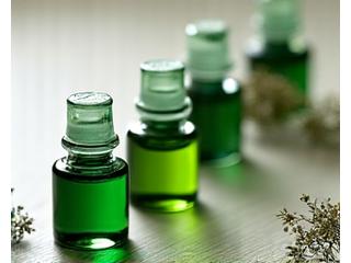 Vials of vibrant, natural green calligraphy inks, showing clarity and depth, alongside botanical elements.